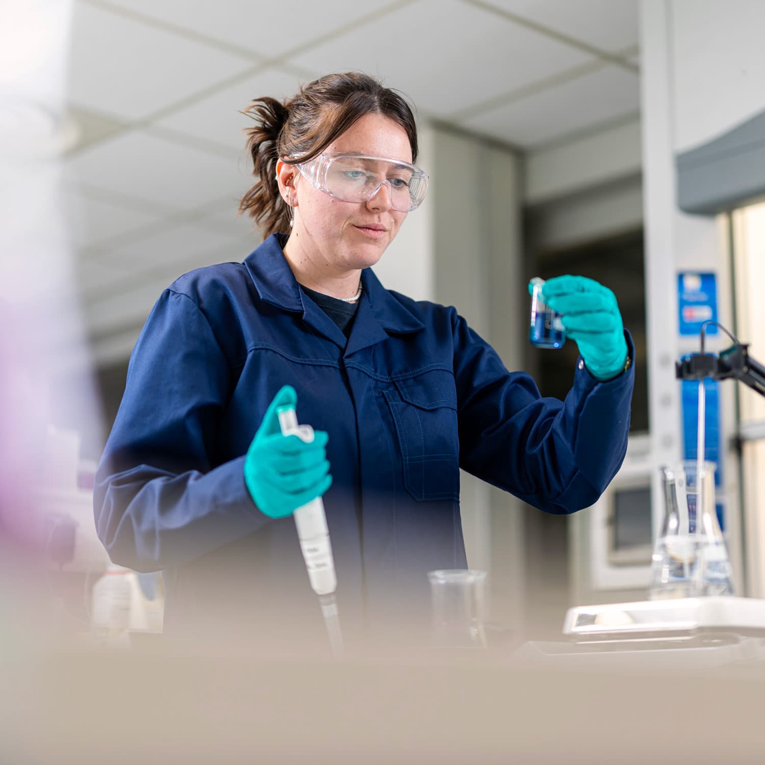 Technicienne de laboratoire manipulant un échantillon chimique