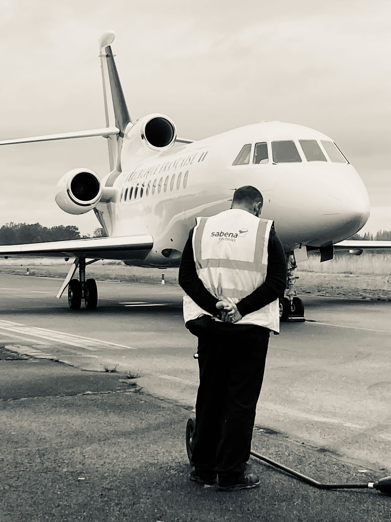 Sabena technics staff member facing a French Republic Falcon on the tarmac at Villacoublay