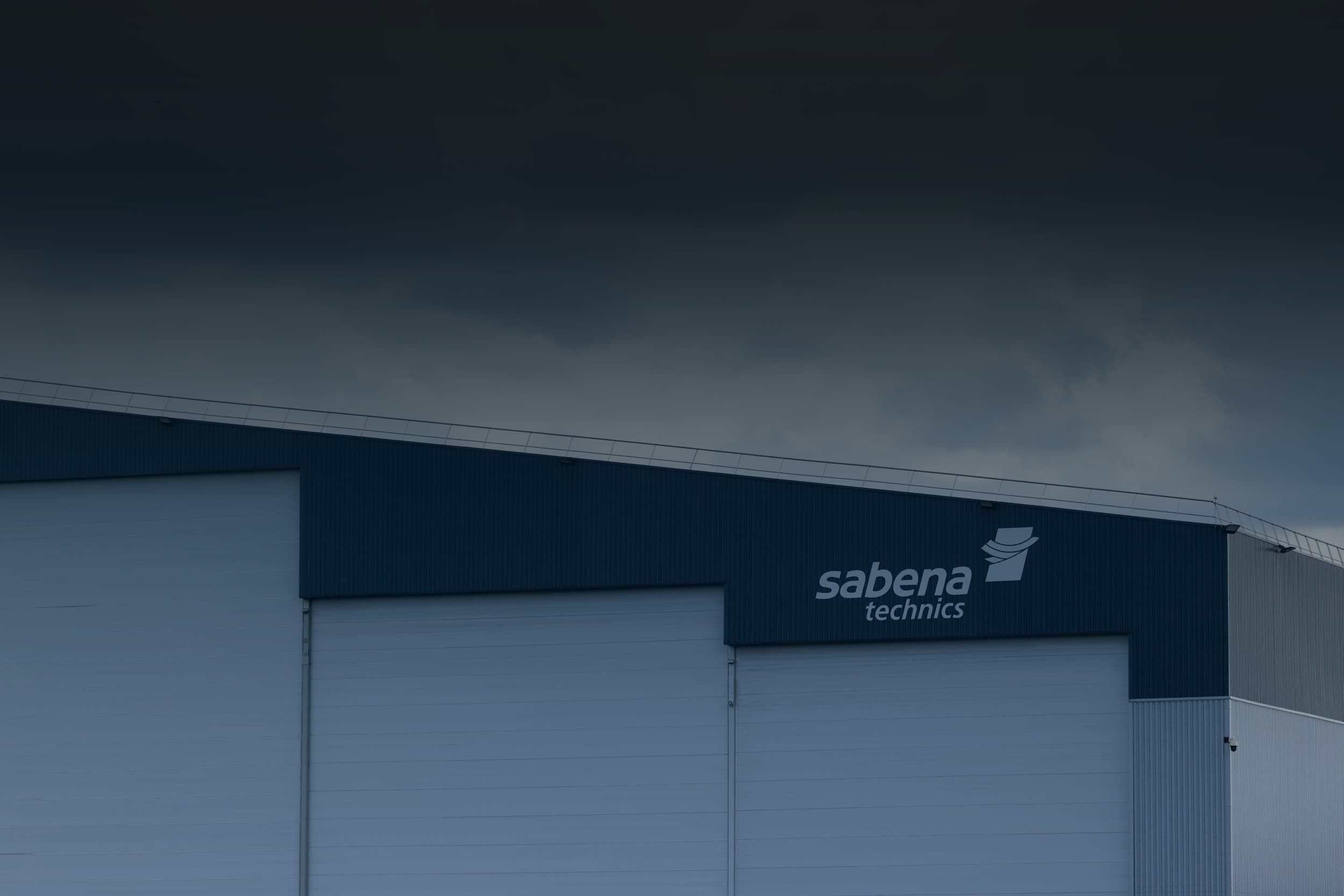 Vue extérieure d’un hangar de maintenance Sabena technics avec logo visible sur la façade