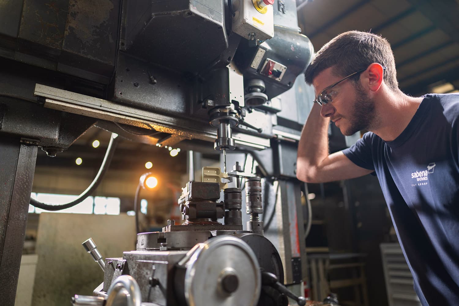Sabena technics technician machining a custom part in the workshop, illustrating careers in aeronautical maintenance
