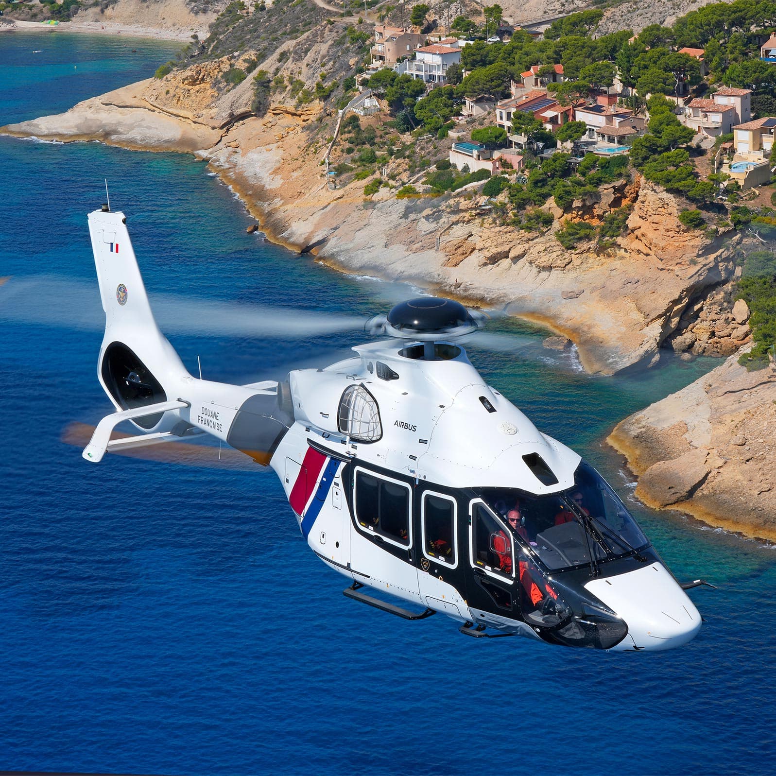 French H160 helicopter flying over the coastline as part of a maintenance project carried out by Sabena technics