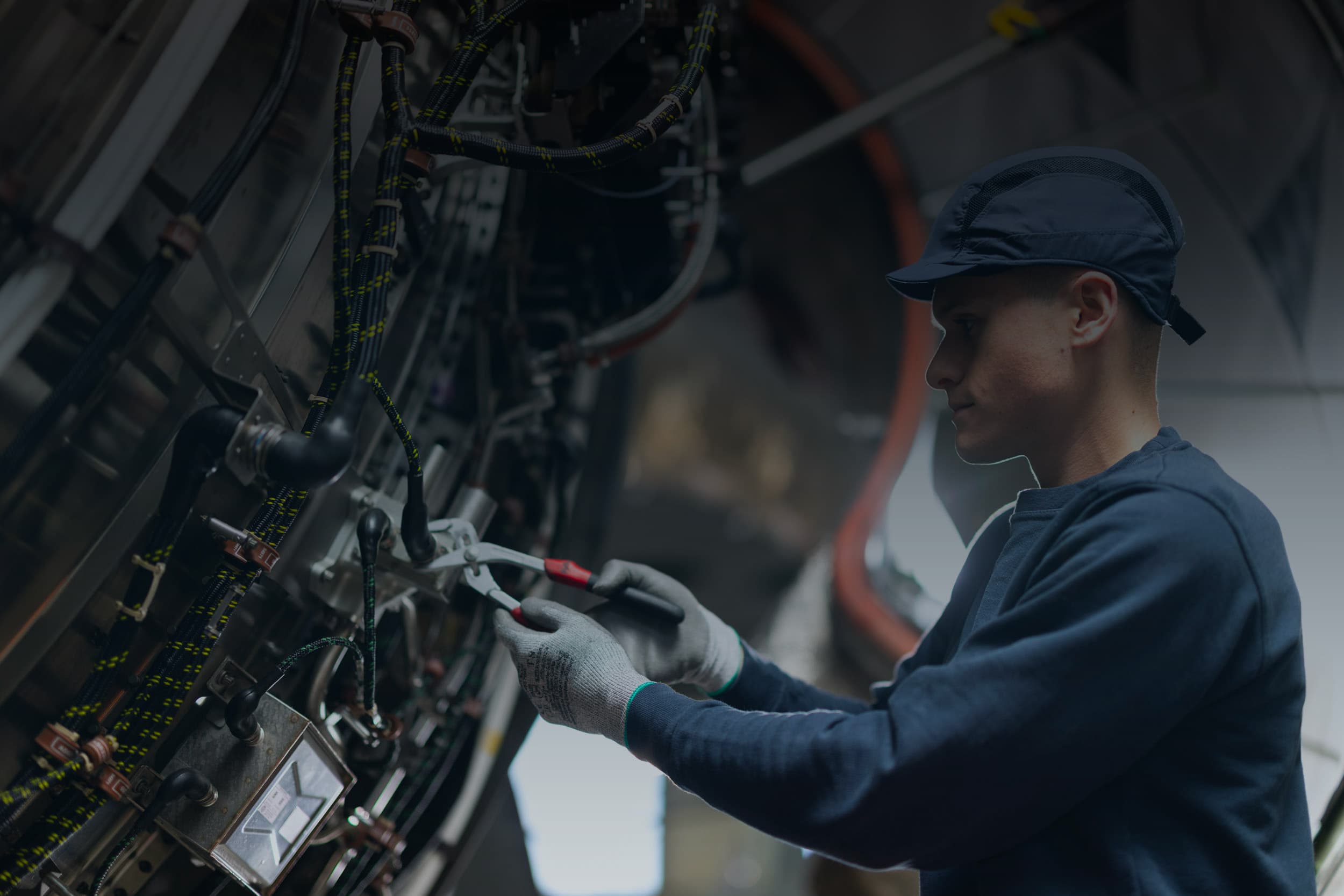 Sabena technics technician working on a complex wired system inside an aircraft