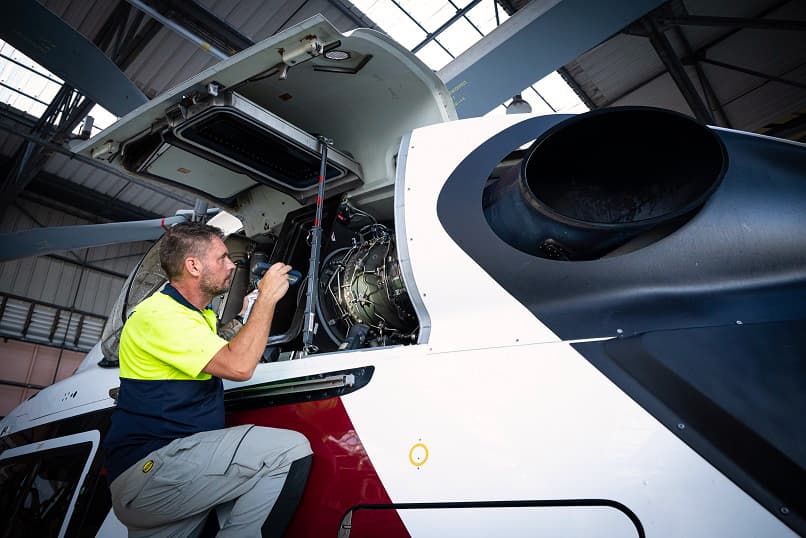 Sabena technics B1 technician carrying out mechanical maintenance on a helicopter inside a hangar